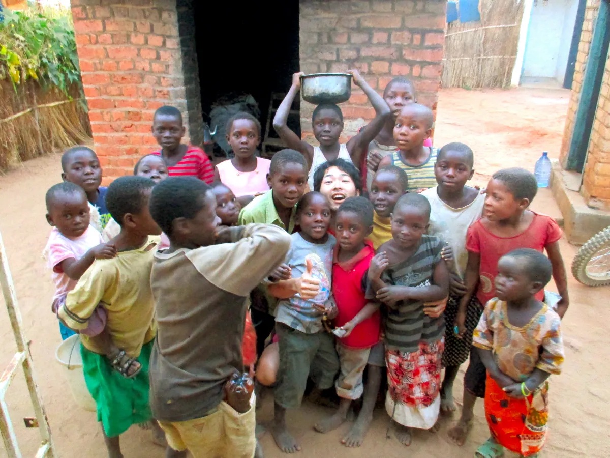 笑顔で過ごすアフリカ・マラウイの子ども達と庄田さんの画像