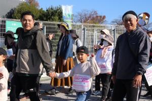 出発時に笑顔で通り過ぎる男性二人と手を振る男の子