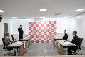 会見時に立って挨拶する武井市長