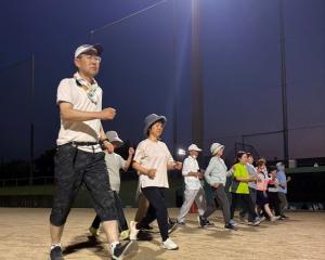 穂波野球場でウォーキングする講座参加者