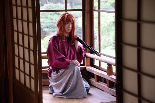 刀を肩にかけ写真撮影に臨むコスプレイヤー