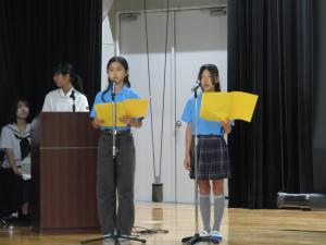 台本を手に、マイクに向かって英語のスピーチを披露する中学生