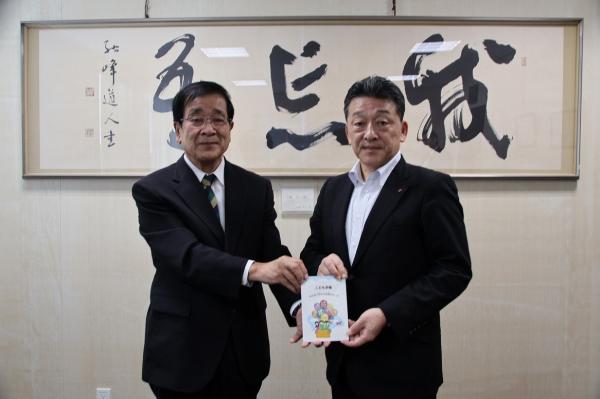 公益財団法人日本公衆電話会から冊子「こども手帳～みんなで守ろう社会のルール～」を受け取る桑原教育長