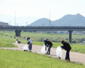 「I LOVE 遠賀川」でボタ山を背にゴミ拾いをする参加者