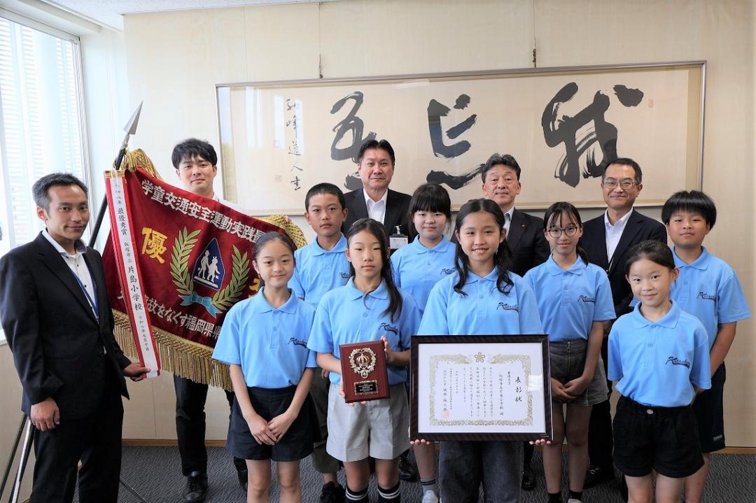 深紅の優勝旗と共に写真に収まる片島小学校児童の皆さんたち