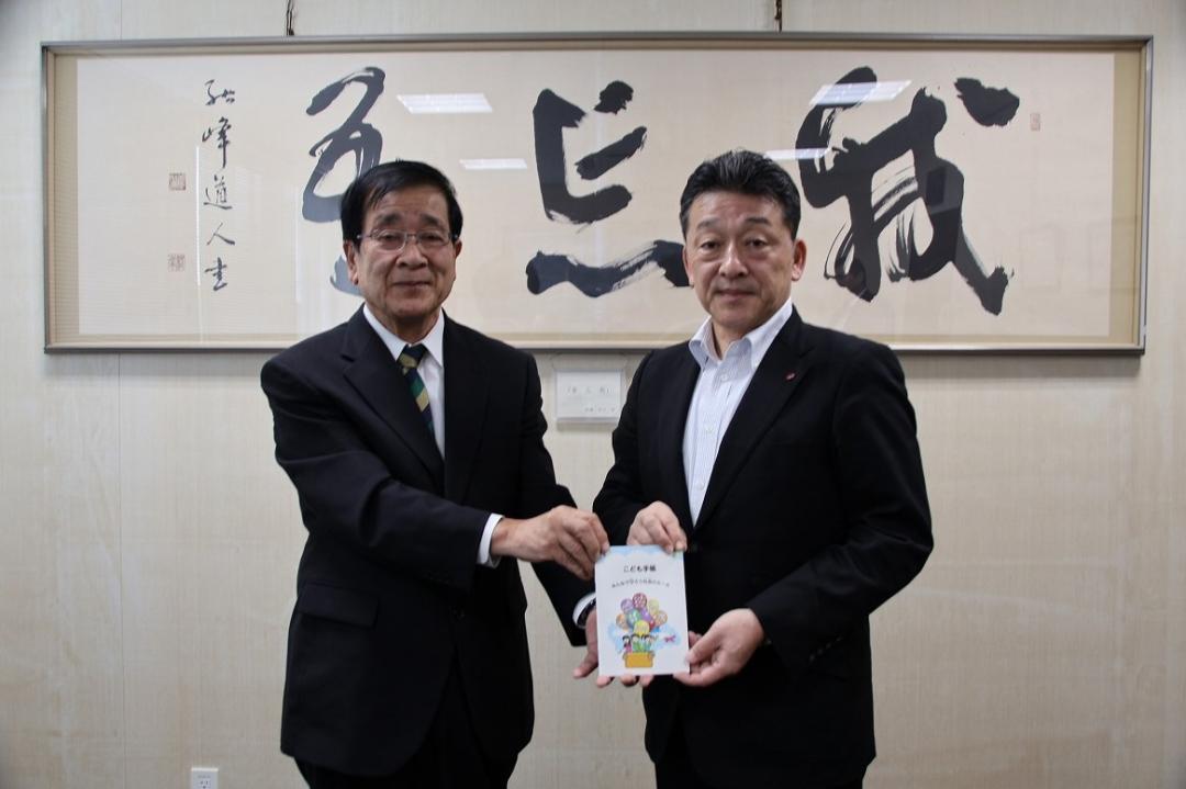 公益財団法人日本公衆電話会から冊子「こども手帳~みんなで守ろう社会のルール~」を受け取る桑原教育長