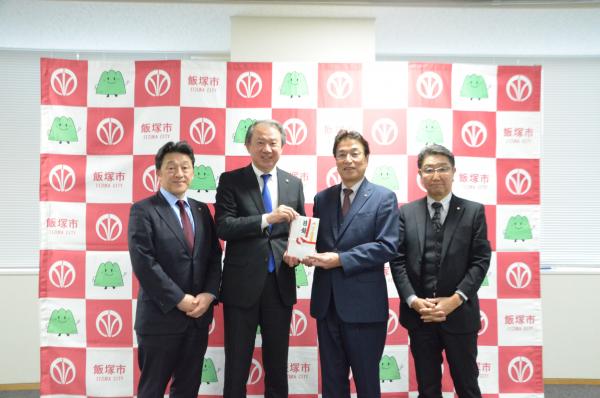 図書カードの寄贈式で正中良樹理事長から武井市長に図書カード(目録)が手渡された写真